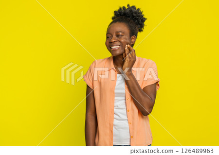 Black woman touching cheek closing eyes with expression of terrible suffer from painful toothache Black woman touching cheek closing eyes with expression of terrible suffer from painful toothache 126489963