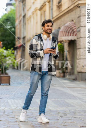 Tourist man using smartphone looking for search way on map in mobile navigator app on city street 126490144