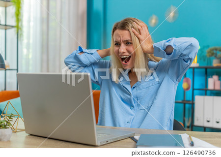 Displeased businesswoman using laptop surprised bad news fortune loss game fail computer virus error 126490736