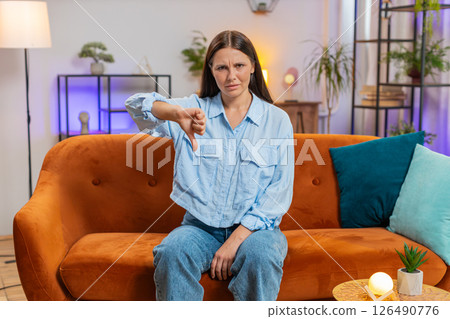Upset unhappy young woman showing thumbs down sign dislike gesture disapproval bad work feedback 126490776