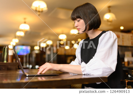 Woman working on laptop in cafe Woman working on laptop in cafe 126490913