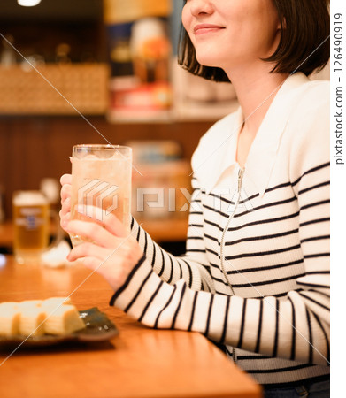 A woman drinking at a pub A woman drinking at a pub 126490919
