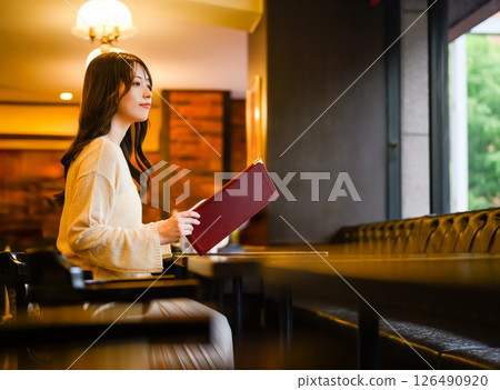 A female customer perusing the menu 126490920