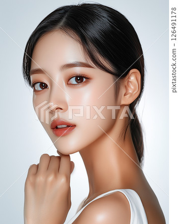 Radiant Korean beauty showcasing skincare techniques for a natural glow in a studio setting 126491178