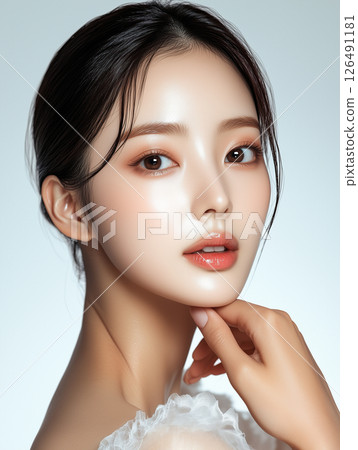 Korean skincare techniques showcased by model demonstrating glowing complexion and healthy skin radiance in studio setting 126491181