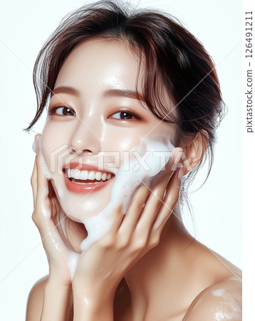 Korean woman performing skincare routine with foam cleanser and smiling brightly 126491211