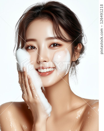 Glowing Korean beauty practicing skincare routine with foamy cleanser in bright setting 126491218