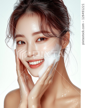 Young Korean woman applying foam skincare product for a fresh and radiant complexion in a bright setting 126491221
