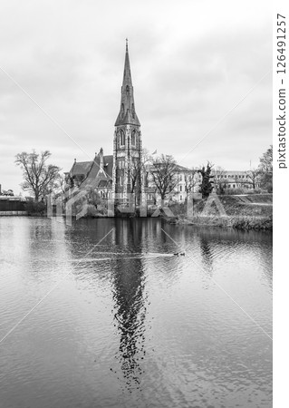 St Alban's Church stands gracefully beside the water in Copenhagen, Denmark. Its spire reaches high as trees surround the tranquil scene, creating a picturesque and serene atmosphere. St Alban's Church stands gracefully beside the water in Copenhagen, Denmark. Its spire reaches high as trees surround the tranquil scene, creating a picturesque and serene atmosphere. 126491257