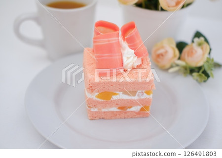 Piece of cake and cup of tea on white background, stock photo 126491803