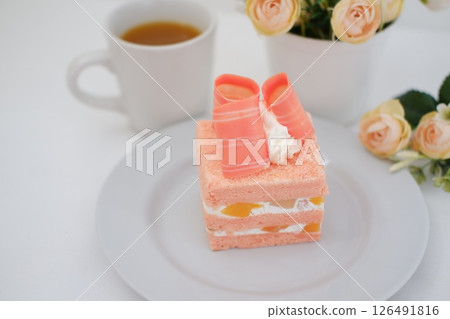 Piece of cake and cup of tea on white background, stock photo 126491816