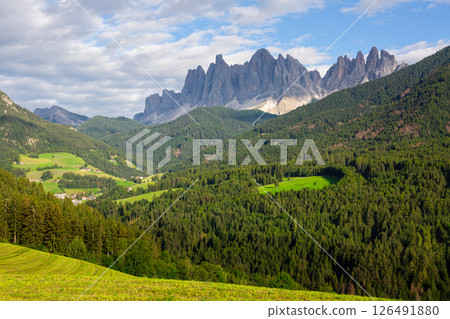 Green valley of Val di Funes at foot of rocky Italian Dolomites with rustic houses Green valley of Val di Funes at foot of rocky Italian Dolomites with rustic houses 126491880