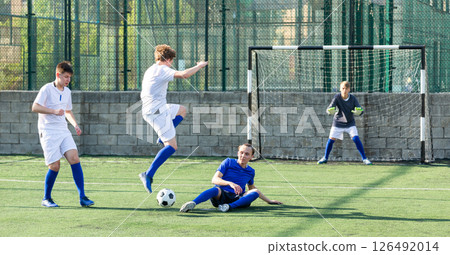 Teens playing soccer football match. Competition between two youth soccer teams Teens playing soccer football match. Competition between two youth soccer teams 126492014