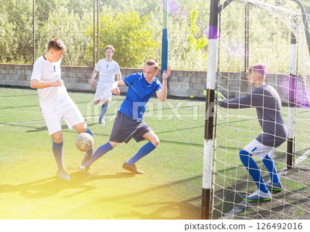 Junior football teams having golmouth scramble 126492016