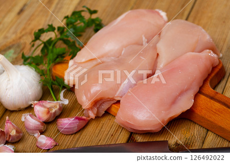 Raw chicken breast fillet with garlic and greens 126492022