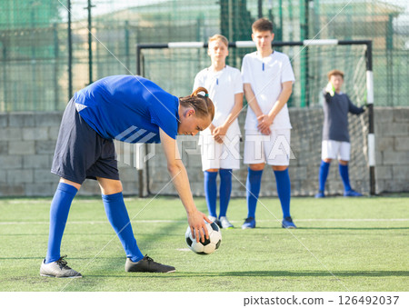 Football player putting ball for kick Football player putting ball for kick 126492037