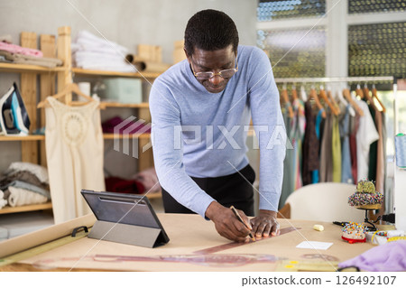 Fashion designer creating clothing patterns in studio 126492107