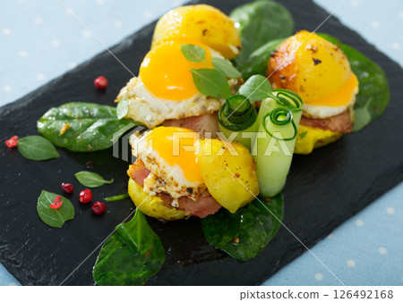 Close up of mini burgers from quail eggs with baked potatoes at plate with greens Close up of mini burgers from quail eggs with baked potatoes at plate with greens 126492168
