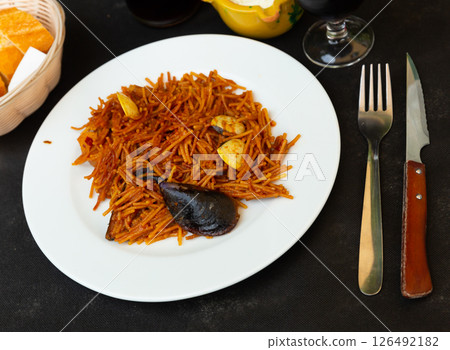 Spanish seafood fideua, noodle paella with aioli 126492182