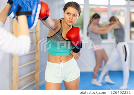Teen girl in punch mitts boxing 126492221
