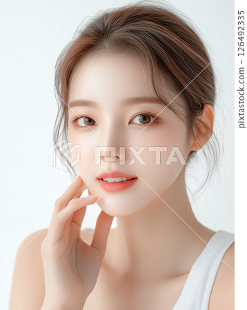 Korean woman showcasing flawless skincare routine with gentle touch and natural beauty 126492335