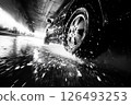 Dynamic car wash view showcasing a close up of water splashes and tires in motion under an overpass 126493253