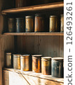 Oil cans arranged symmetrically on wooden shelves creating an aesthetic display in a rustic setting with warm lighting and earthy tones 126493261