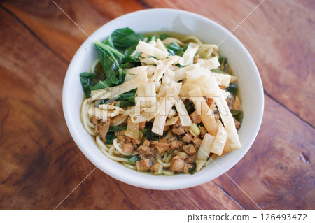 Fried noodle in white bowl on wooden table Fried noodle in white bowl on wooden table 126493472
