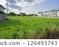 Grassy vacant lot and residential area 126493743