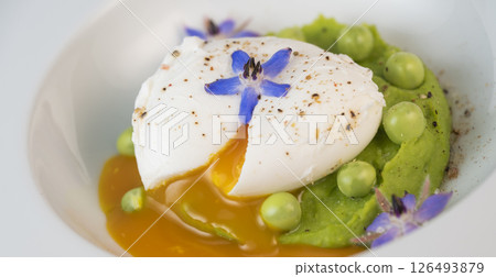 Delicious fresh pea puree topped with a perfectly poached egg and garnished with borage flowers for 126493879