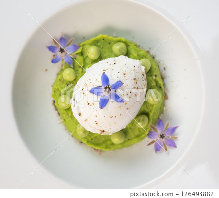 Delicious fresh pea puree topped with a perfectly poached egg and garnished with borage flowers for 126493882