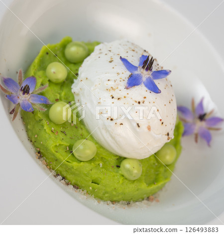 Delicious fresh pea puree topped with a perfectly poached egg and garnished with borage flowers for 126493883