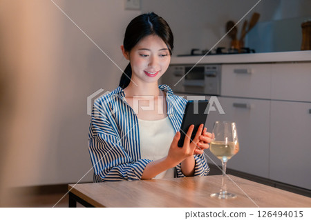 A young woman having a drink alone at night 126494015
