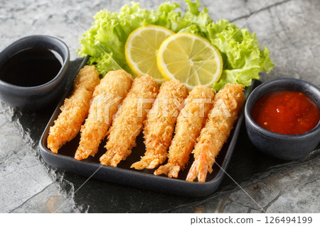 Japanese king prawns tempura served with lemon and lettuce and two sauces close-up. horizontal Japanese king prawns tempura served with lemon and lettuce and two sauces close-up. horizontal 126494199