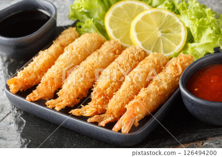 Delicious tempura shrimp served with lemon and lettuce and two sauces close-up. horizontal Delicious tempura shrimp served with lemon and lettuce and two sauces close-up. horizontal 126494200