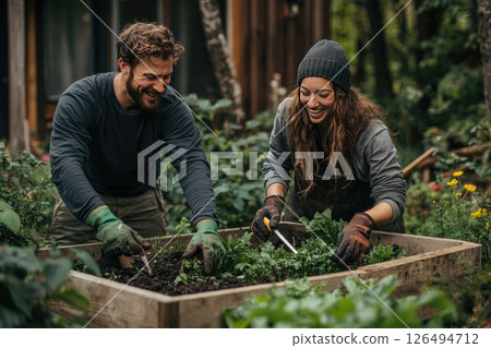 Two smiling gardeners working together in a lush vegetable garden, enjoying their outdoor activity Two smiling gardeners working together in a lush vegetable garden, enjoying their outdoor activity 126494712