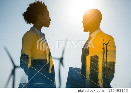 Vibrant Startup Team Brainstorming Solar Panel Ideas with Wind Turbines in Background Vibrant Startup Team Brainstorming Solar Panel Ideas with Wind Turbines in Background 126495153