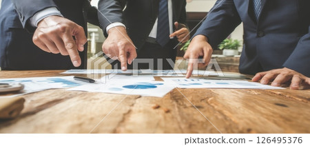 Confident Business People Analyzing Graphs and Data During a Meeting in Office Setting Confident Business People Analyzing Graphs and Data During a Meeting in Office Setting 126495376