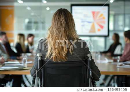 Business Meeting with Attendees Listening from a Wheelchair at Modern Office Conference Room Business Meeting with Attendees Listening from a Wheelchair at Modern Office Conference Room 126495406