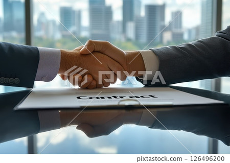 Successful Business Deal Closing with Handshake and Contract on Table in Modern Office Setting 126496200
