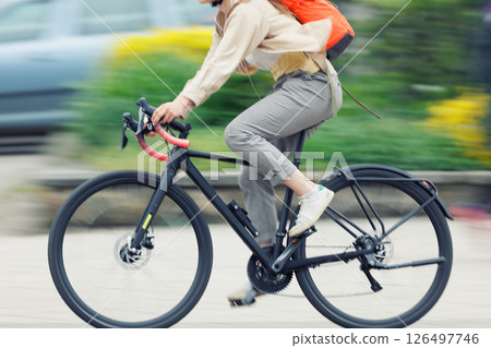 Woman wear casual suit cycling vintage bicycle on European city street dynamic motion blurred background on sunny day. Urban bike commute work ride employee healthy lifestyle eco-friendly transport Woman wear casual suit cycling vintage bicycle on European city street dynamic motion blurred background on sunny day. Urban bike commute work ride employee healthy lifestyle eco-friendly transport 126497746
