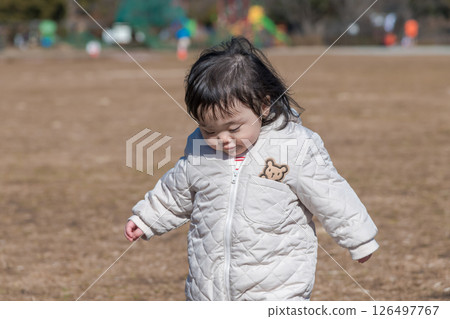 [A one-year-old child playing on the grass at Sagamihara Municipal Asamizo Park] 126497767