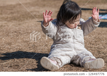 [相模原市立麻溝公園，一位一歲兒童坐在草地上玩耍] 126497776