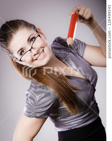 Teacher looking elegant woman holding big pencil Teacher looking elegant woman holding big pencil 126499545