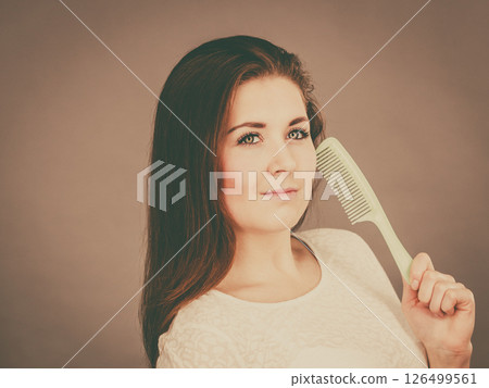 Happy woman brushing her hair 126499561