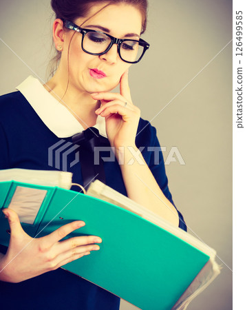 woman thinking holds file folder with documents woman thinking holds file folder with documents 126499585