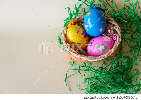 Easter color eggs in nature wicker basket on pastel background. Flat lay. Top view with copy space. Easter concept. 126499673