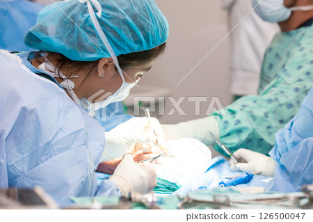 Female doctor performing a surgery. Orthopedic surgeon. Surgery and insurance concept. Hand surgery. Traumatology and orthopedics concept. 126500047