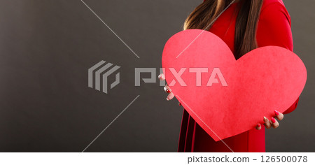 Girl holding big red heart in hands 126500078