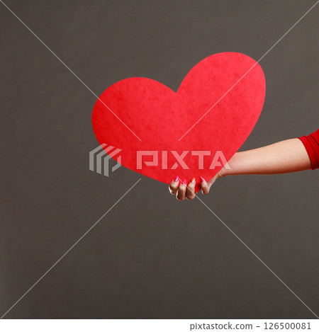 Girl holding big red heart in hands 126500081